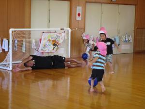 ゴールを狙う子ども達とゴールキーパーをしている写真