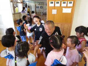元日本代表サッカー選手とハイタッチをしている写真
