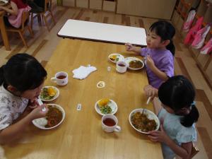 きりん組が自分たちで作ったカレーライスを食べている写真